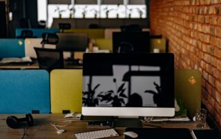 Empty modern office desk with single computer monitor glowing in quiet workspace