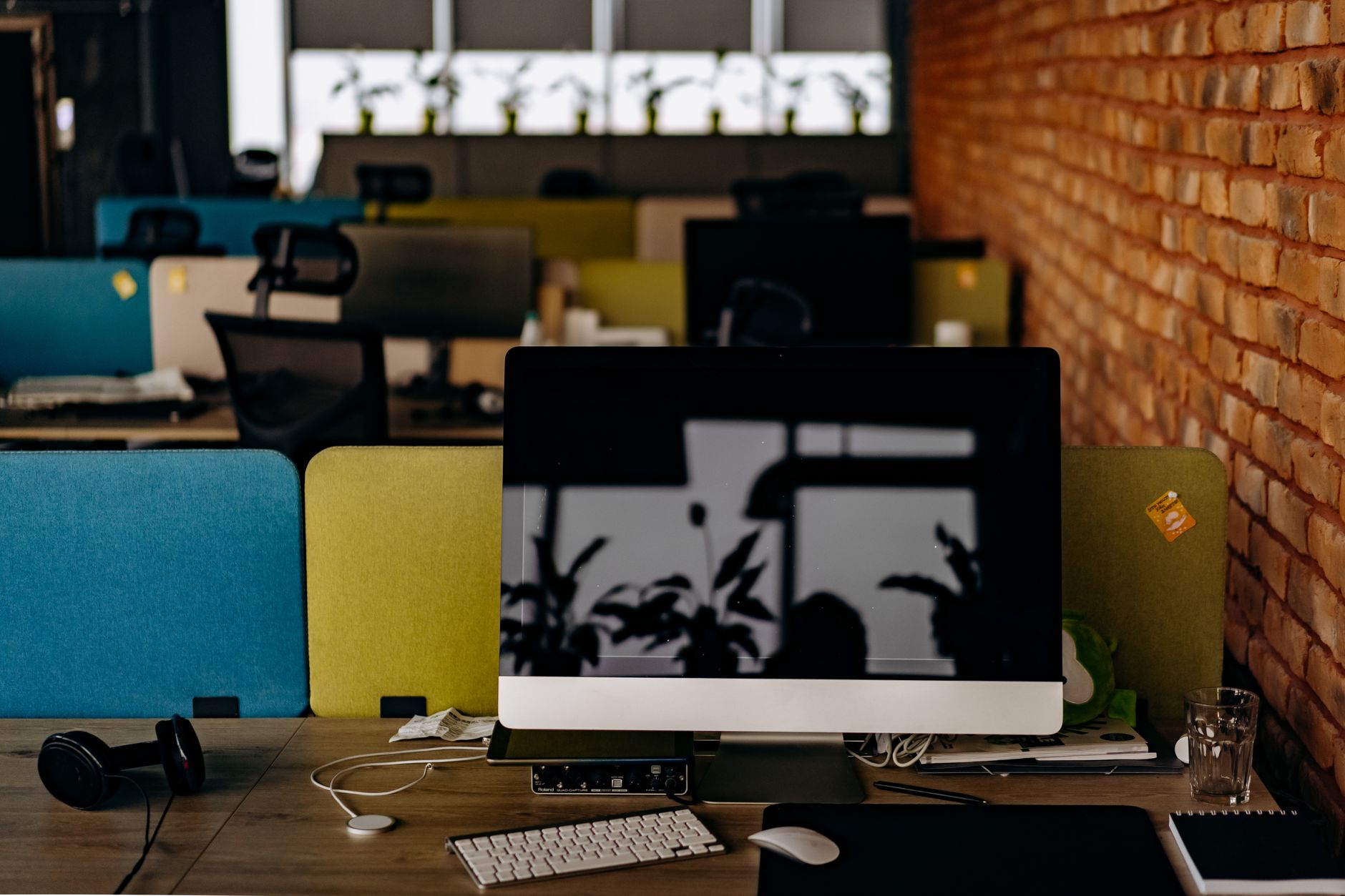 Empty modern office desk with single computer monitor glowing in quiet workspace