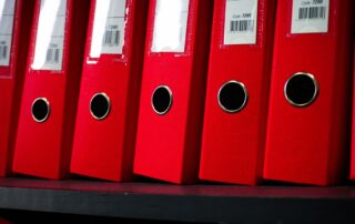 Close-up of red office binders neatly arranged on a shelf
