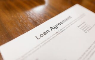 Close-up of a printed loan agreement document lying on a wooden table