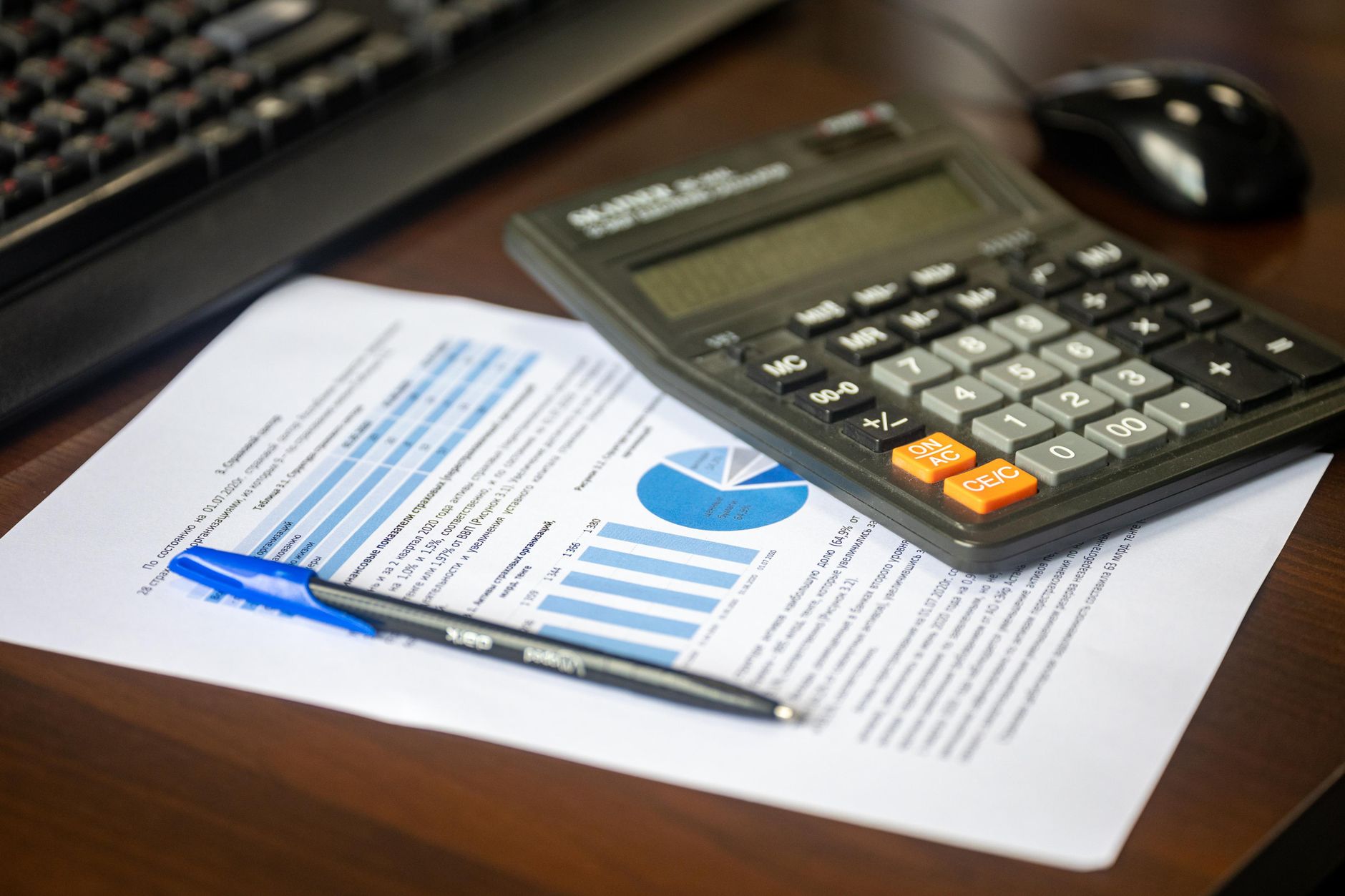 Desk with calculator, financial report, and pen for business analysis
