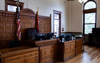 Empty judge's bench with flags inside a quiet American courthouse