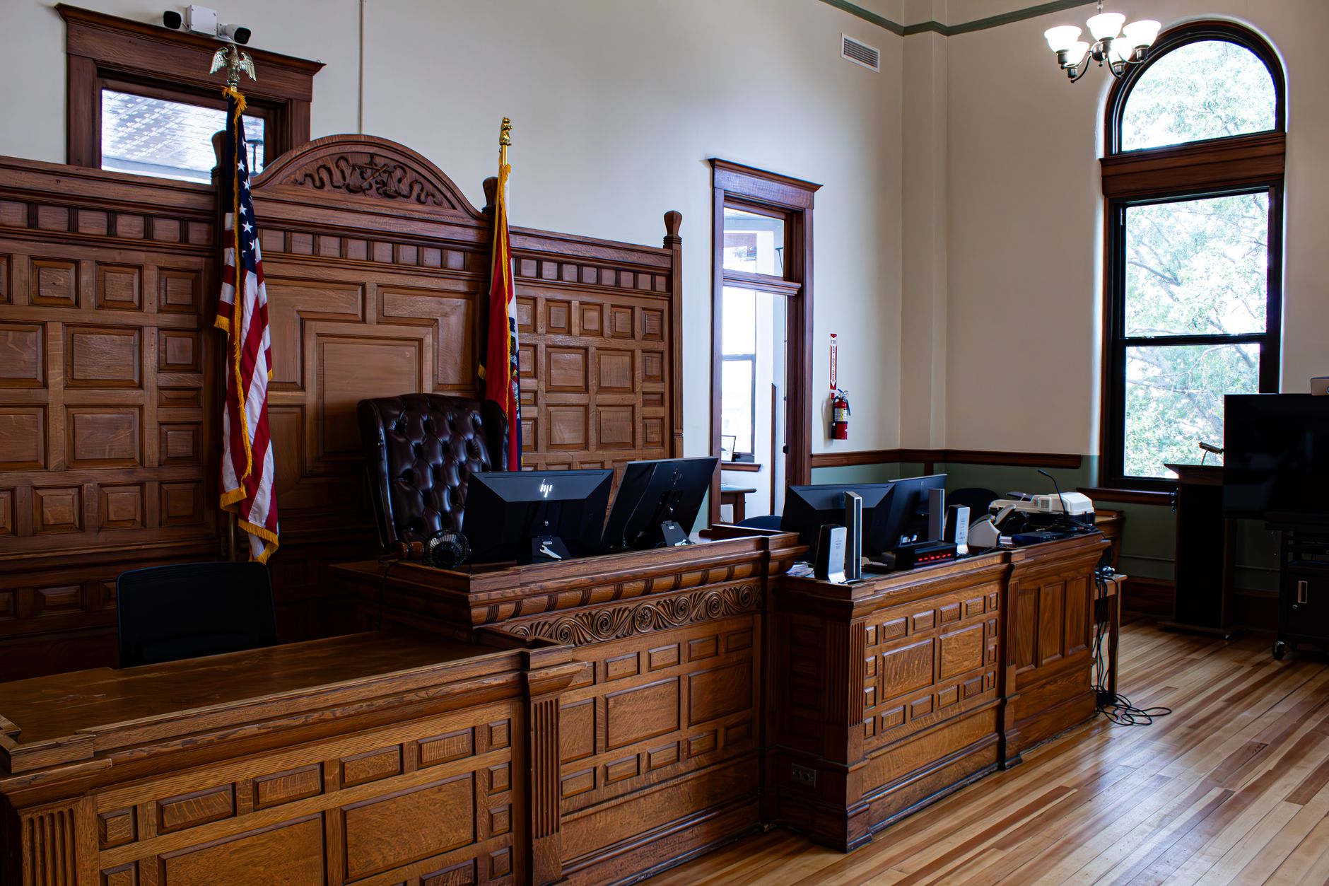 Empty judge's bench with flags inside a quiet American courthouse